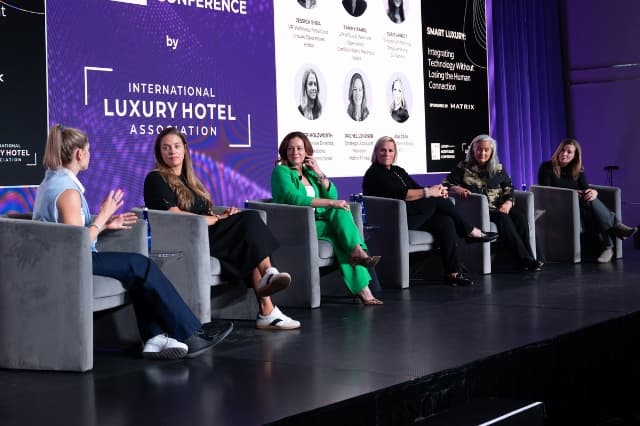 Panel of six female hospitality leaders speaking on stage at the INSPIRE conference.
