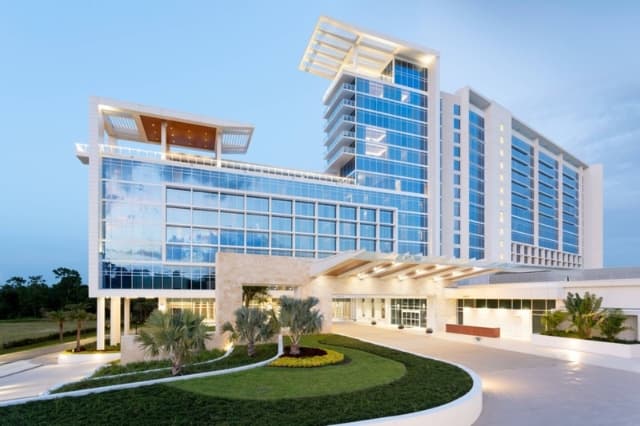 Ground-level view of the modern JW Marriott hotel exterior and entrance at dusk.