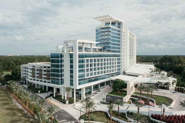 Aerial daytime view of the JW Marriott hotel exterior, showing the high-rise structure and driveway.