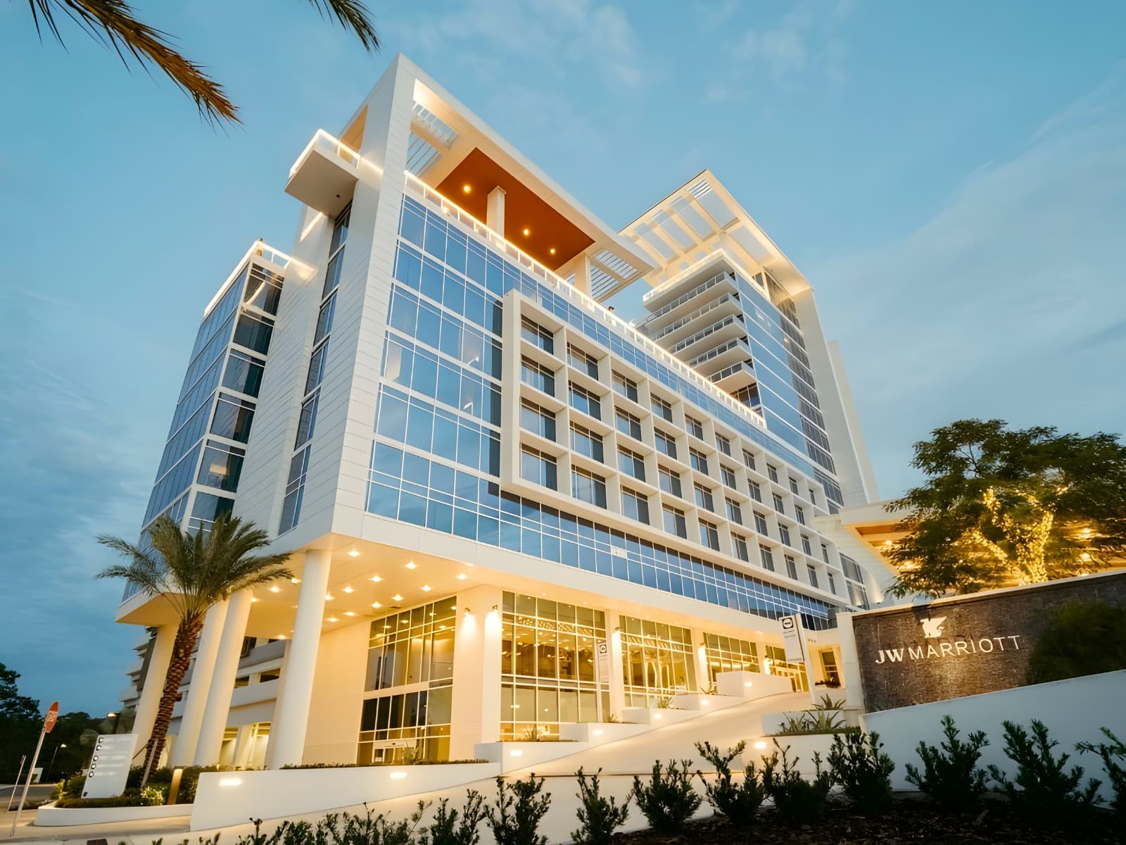 Exterior view of a modern high-rise JW Marriott hotel at dusk.